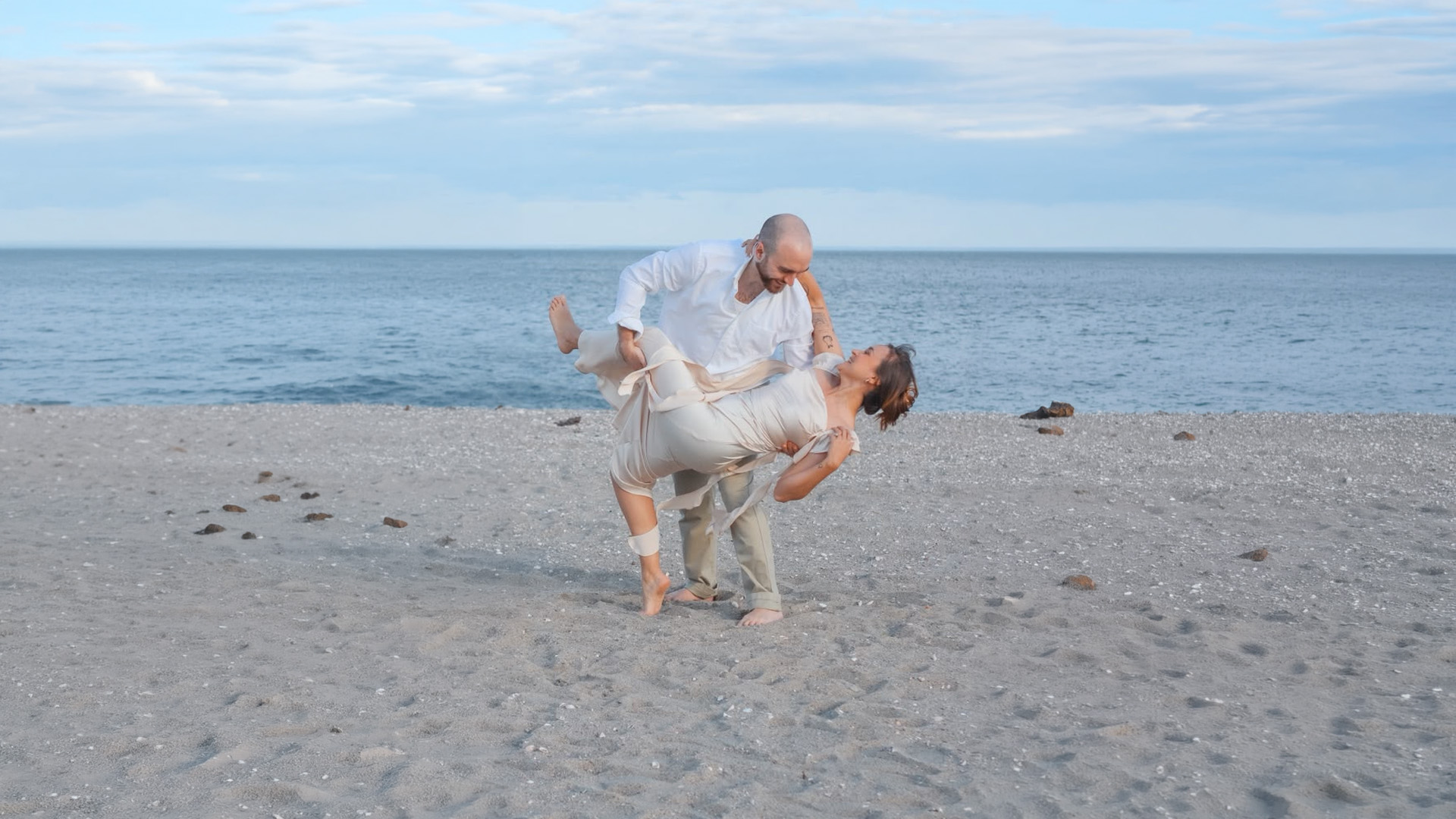 A couple in a romantic dip on a New England beach at dusk